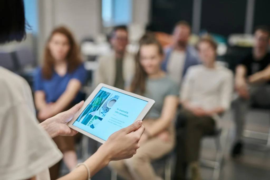 Ομιλήτρια παρουσιάζει με tablet σε συμμετέχοντες σεμιναρίου